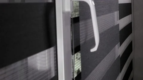Closing rolling shutter or roller blind on a sunny day. Window roller duo system 库存影片 186726398