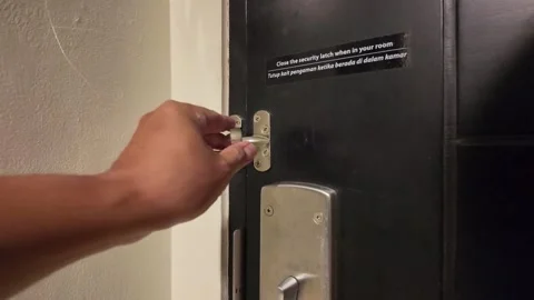 Closing Security Chain Latch on a Hotel Room Door Stock Footage 344087577