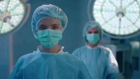 A closing in shot of two nurses wearing full surgical uniform and standing in a Stock Footage 221777538
