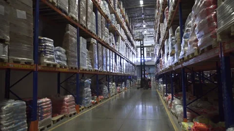 A closing in shot on a working forklift inside a huge warehouse. Stock Footage 143992307