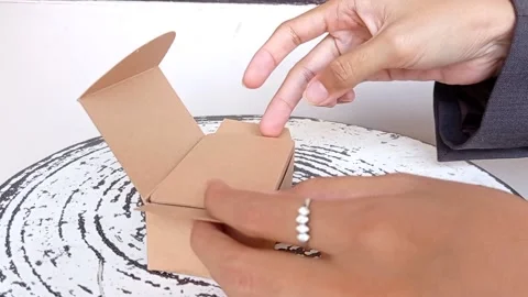 Closing a tiny brown box for a gift Stock Footage 145621215