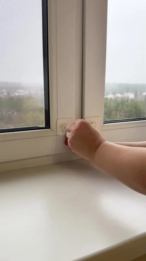 Closing window and locking child safety blocker with key demonstration closeup Stock Footage 321749612