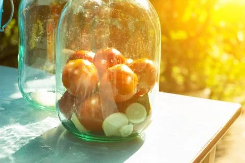 Closure of conservation on the table with tomatoes, sun Photos