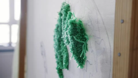 The cloth breaks through the tufting gun, causing pieces of yarn and dust to be Stock Footage 276222576