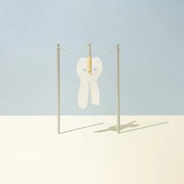 Cloth in the shape of Easter bunny is fasten with clothespin on clothesline Stock Photos