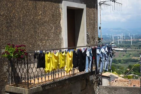 Clothes air drying on a second floor balcony with windmils in the background Stock Photos