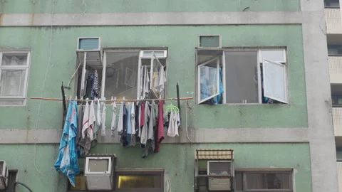 Clothes and linen drying on a window in the slums of Hong Kong Stock Footage 280137160