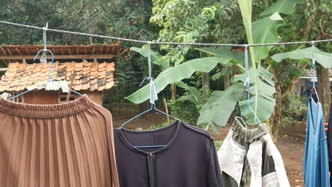 Clothes that are being dried sway in the wind. clothes drying outside Stock Footage 301070322