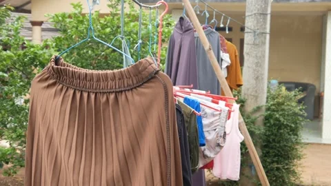 Clothes that are being dried sway in the wind. clothes drying outside Stock Footage 301070323