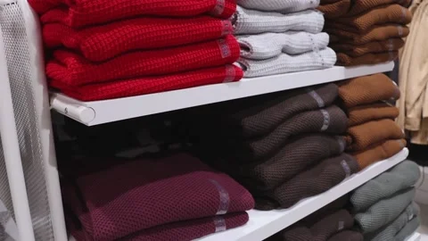 Clothes are on the shelf in the store, stack of sweaters on a shelf in a store Stock Footage 219351288