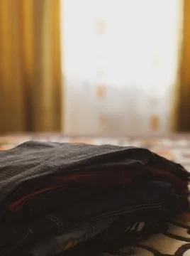 The clothes are stacked on the bed. Stock Photos