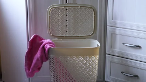 Clothes are thrown into the dirty laundry container for washing in the home.. Stock Footage 232777412