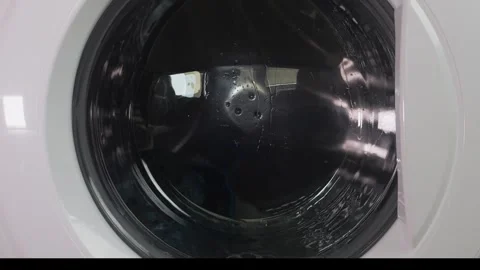 Clothes are washed in a washing machine, the drum with water and detergent .. 動画素材 335318602