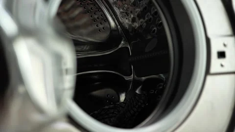 Clothes being tossed into the washing machine to prepare for cleaning Stock Footage 308840637