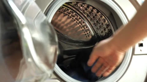 Clothes being tossed into the washing machine to prepare for cleaning 스톡 동영상 308840649