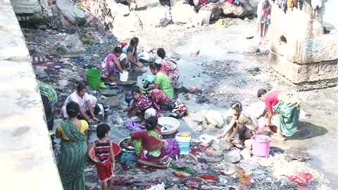CLOTHES BEING WASHED IN UNHYGENIC WATER Stock Footage 130184335