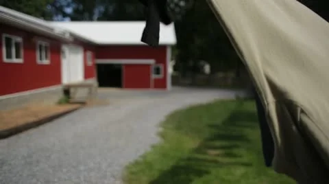 Clothes Blowing on Clothesline in Front of Red Farmhouse Stock Footage 21458262