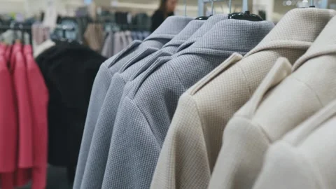 Clothes coats on hangers in a store. Camera movement. Close up. Stock Footage 267981955