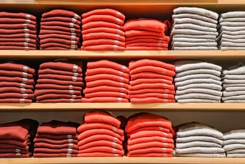 Clothes displayed in store. Copy spase for text. Lot warm sweaters of bright Stock-Fotos