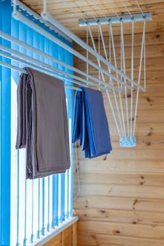 Clothes dryer attached to the ceiling with clothes hanging Stock Photos