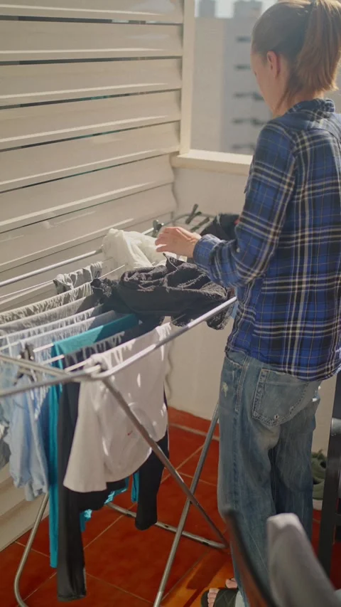 Clothes drying on the balcony in Villajoyosa while a person organizes laundry Stock Footage 335684021