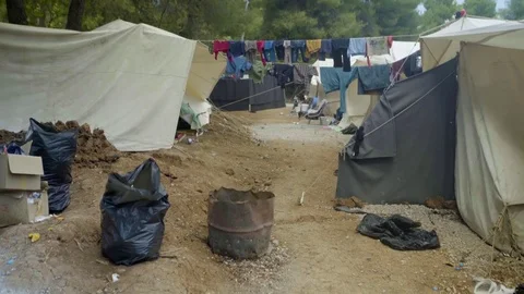 Clothes drying on clothesline and dust bin bags in in Refugee Camp Stock Footage 77452970