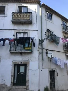 Clothes drying on the facade of a house. Postcard from Lisbon, Portugal. Stock Photos