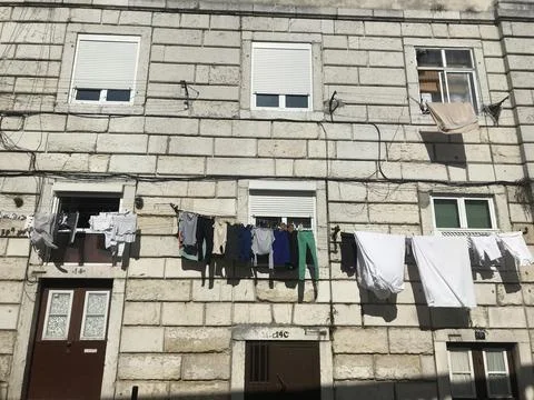 Clothes drying on the facade of a house. Postcard from Lisbon, Portugal. Stock Photos