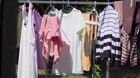 Clothes drying in the little wind on a clothesline outside in the sun , 4k Vídeos de archivo 82395309
