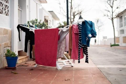 Clothes drying on portable rack outside residential house, everyday domesti.. Stock Photos