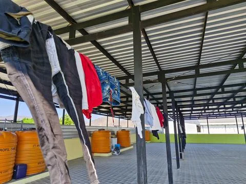 Clothes drying on a rooftop laundry line, with orange water tanks and a met.. Stock Photos