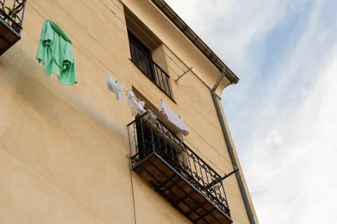 Clothes drying under the sun hanging from balcony in spain Stock Photos