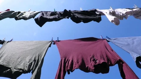 Clothes drying in the wind over blue sky Stock Footage 70656248