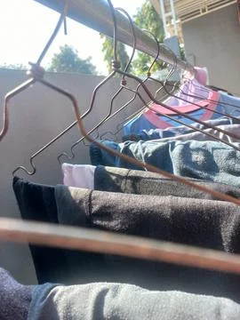 Clothes Drying on Wire Hangers Under Morning Sunlight Outdoors Stock Photos