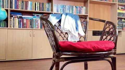 Clothes falling on armchair in library room. Mess at home. Stock Footage 168570871
