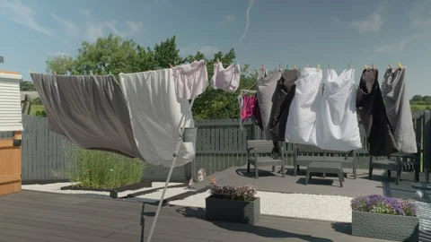 Clothes flutter in gentle breeze on sunny outdoor line Stock Footage 340531281