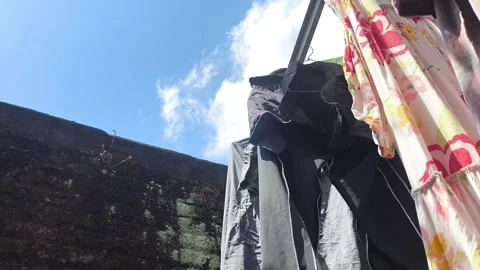 Clothes hang on a line under bright blue sky Stock-Footage 341783272
