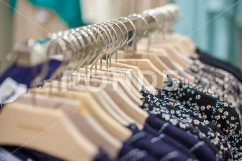 Clothes hang on a shelf. Clothes hanger showcase in store shopping Stock Photos