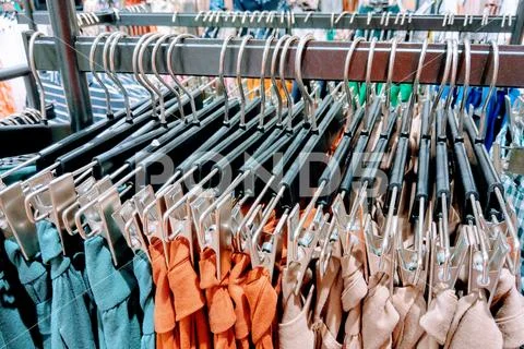 Clothes hang on a shelf in a designer clothes store. Stock Photos