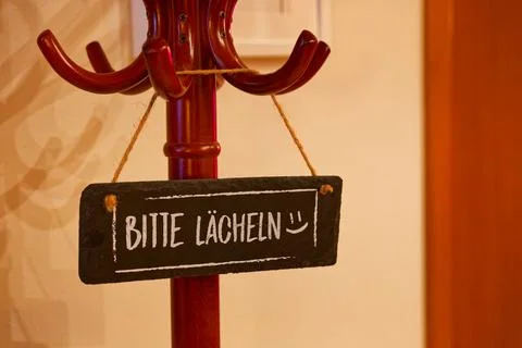 Clothes hanger with Bitte lachen please smile in german language sign and s.. Stock Photos