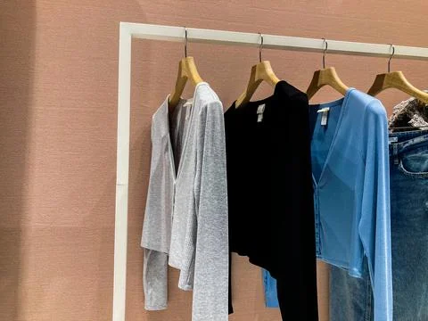 Clothes on hangers in the store. Basic wardrobe sweatshirts hanging on a hang Stock Photos