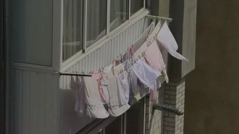 Clothes Hanging on a Balcony in an Urban Setting, Displaying Domestic Life and Stock Footage 309801704