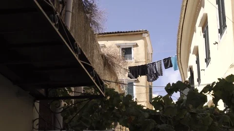 Clothes hanging to dry after cleaning in traditional old town in Corfu Greece Stock Footage 96987461