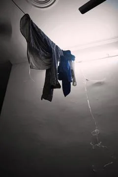 Clothes hanging to dry inside a simple room Stock Photos