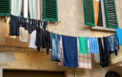 Clothes hanging drying on clothesline in typical italian alley Stock Photos