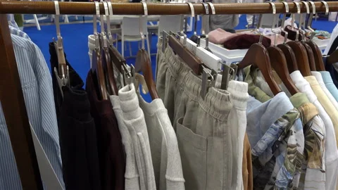Clothes hanging on hangers in a row in a store in 4K. Stock Footage 116338465