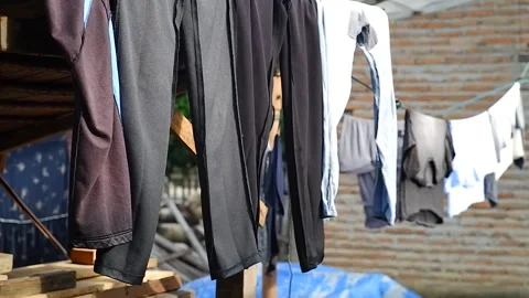 Clothes hanging on a laundry line drying and swaying gently in the wind Stock Footage 337440084