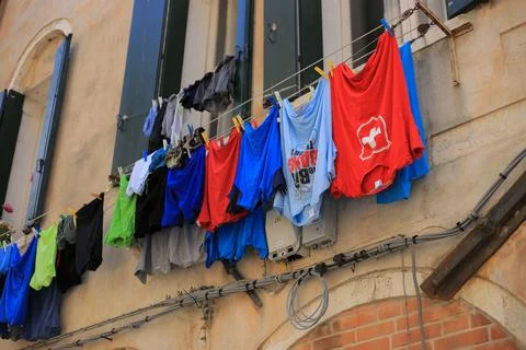 Clothes hanging outside a window to dry Stock Photos