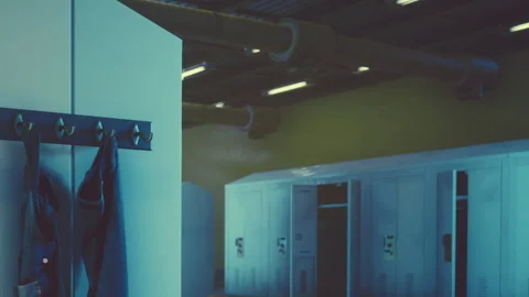 Clothes hanging on a rack in a building with lockers in the background Stock Footage 343502859