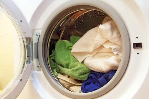 Clothes inside of washing machine. Stock Photos